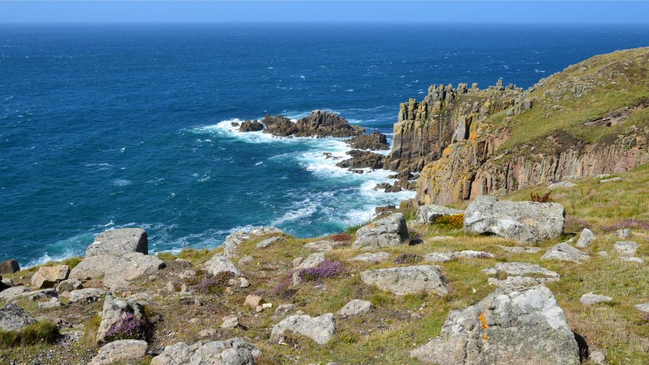 Breathtaking rocky coastline and blue seas at Land's End, England, in summer.